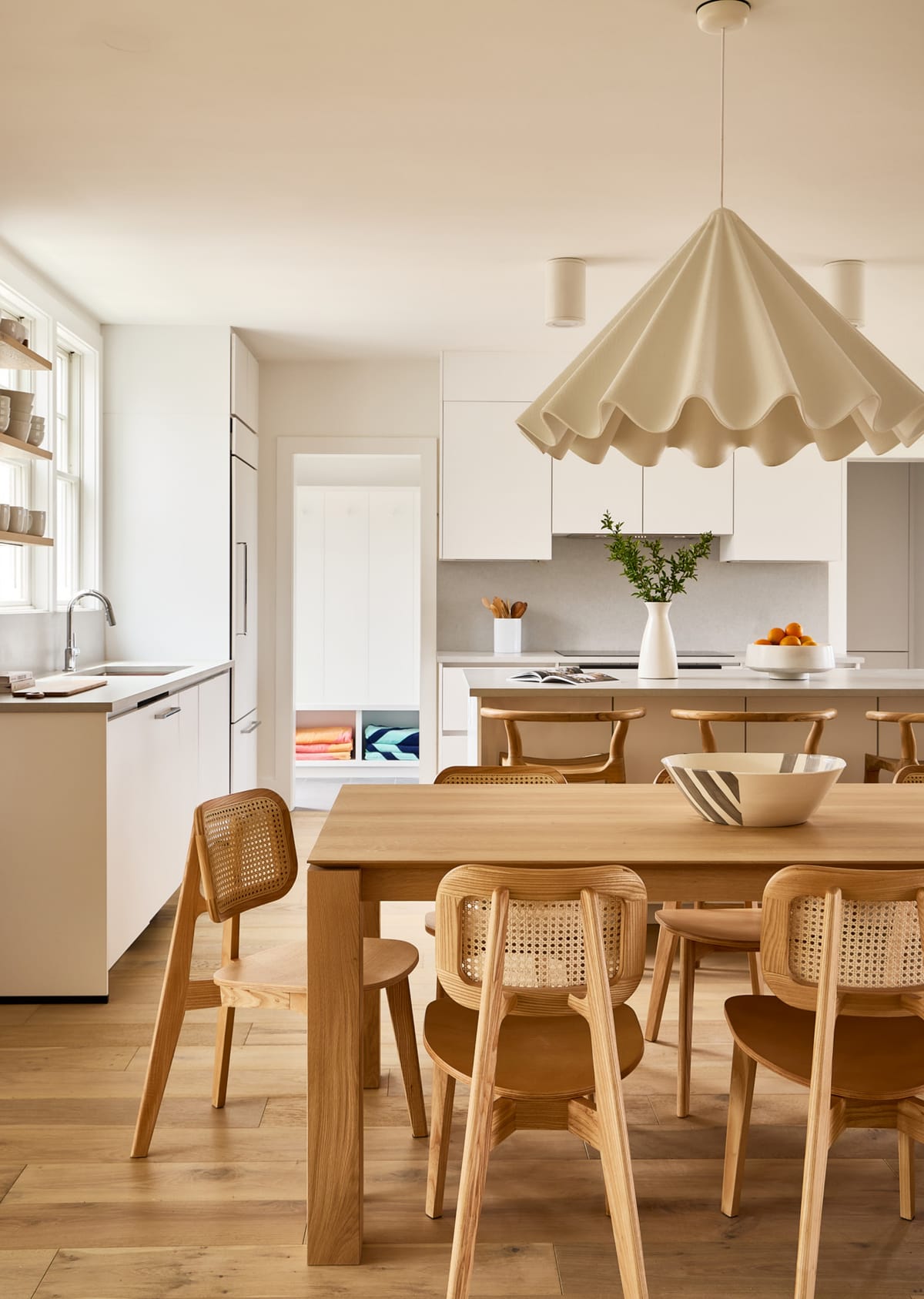 Dining table under a sculptural white pendant