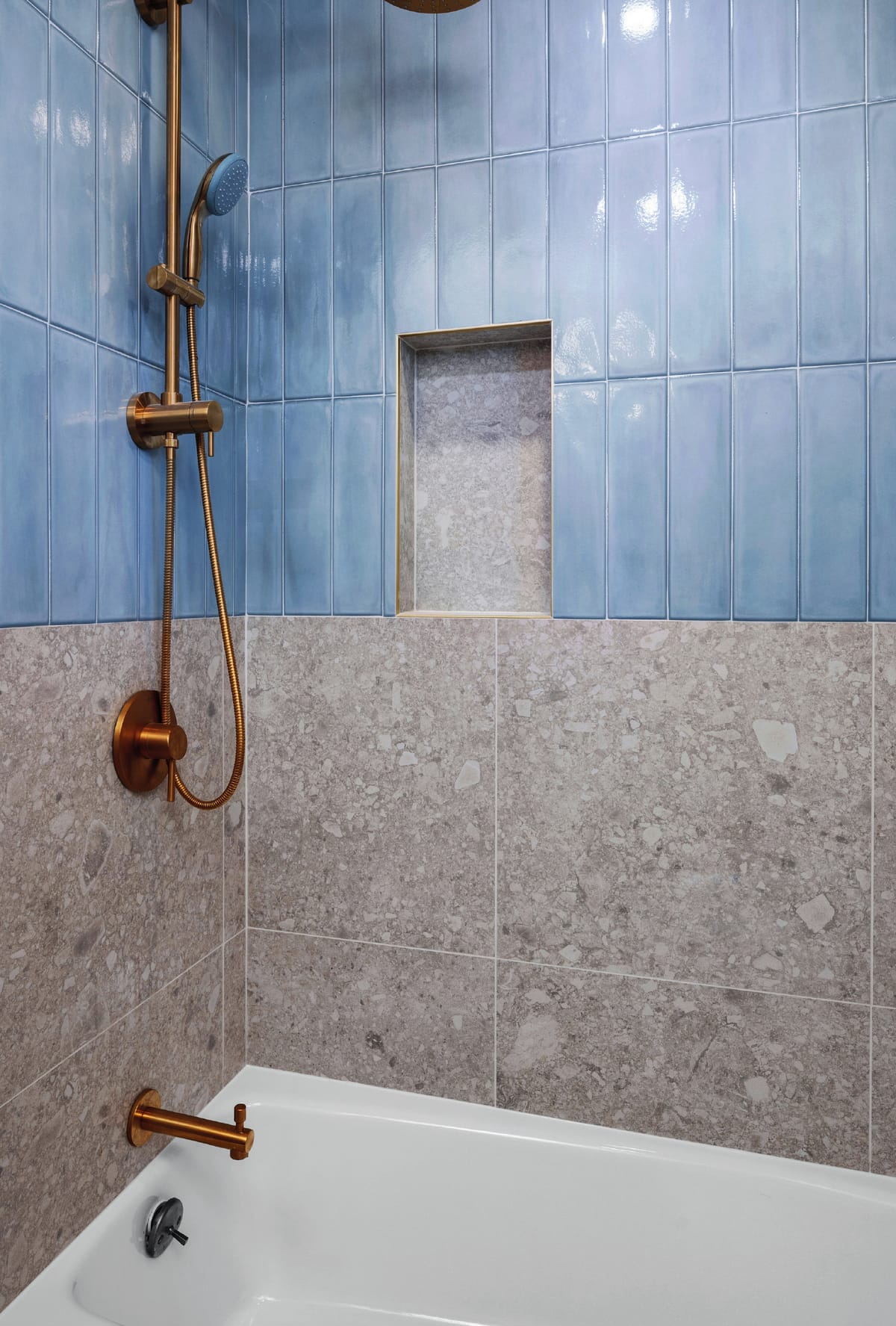 Shower with blue vertical tile and terrazzo