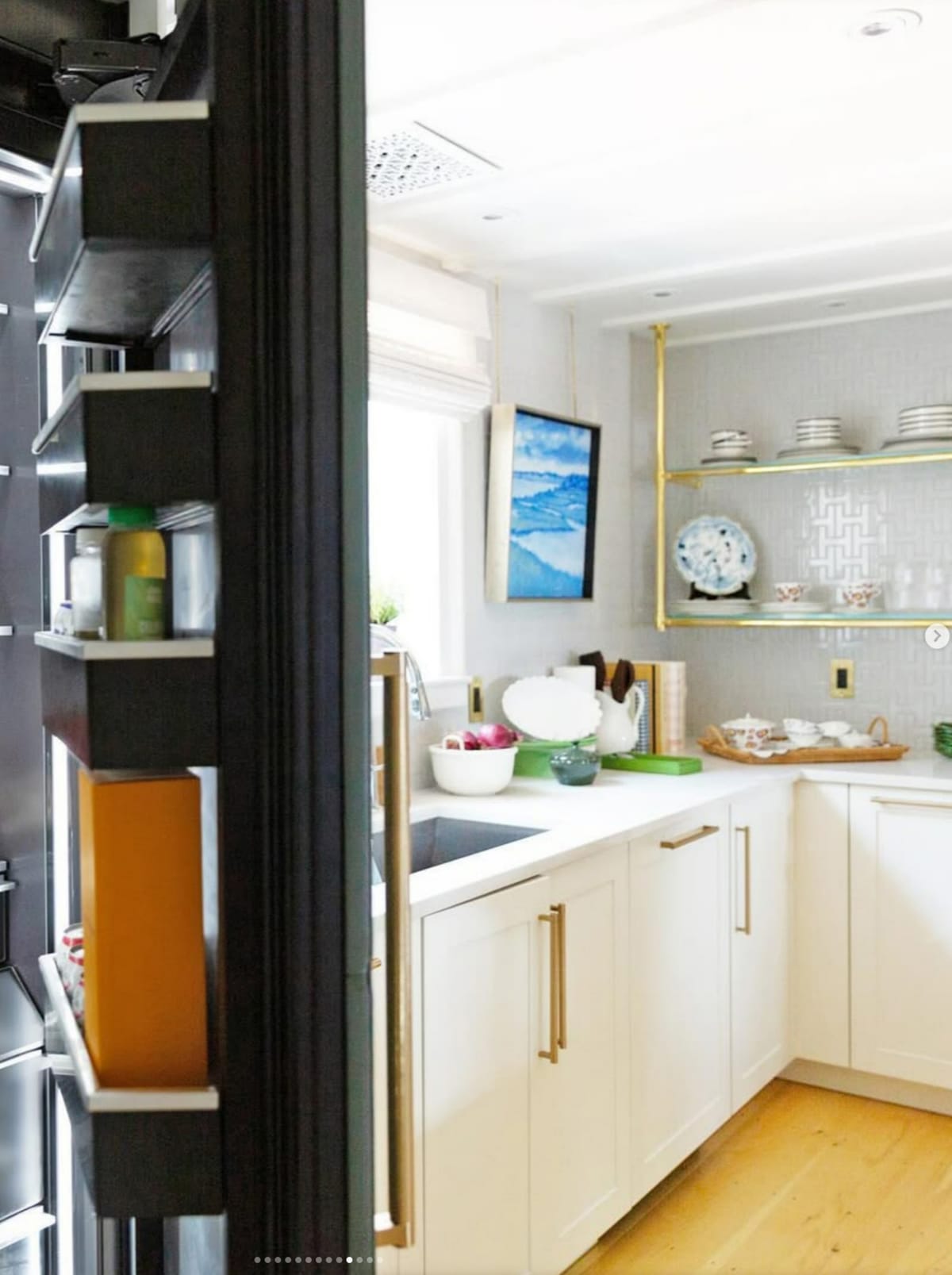 Galley kitchen with white shaker cabinets and brass shelving