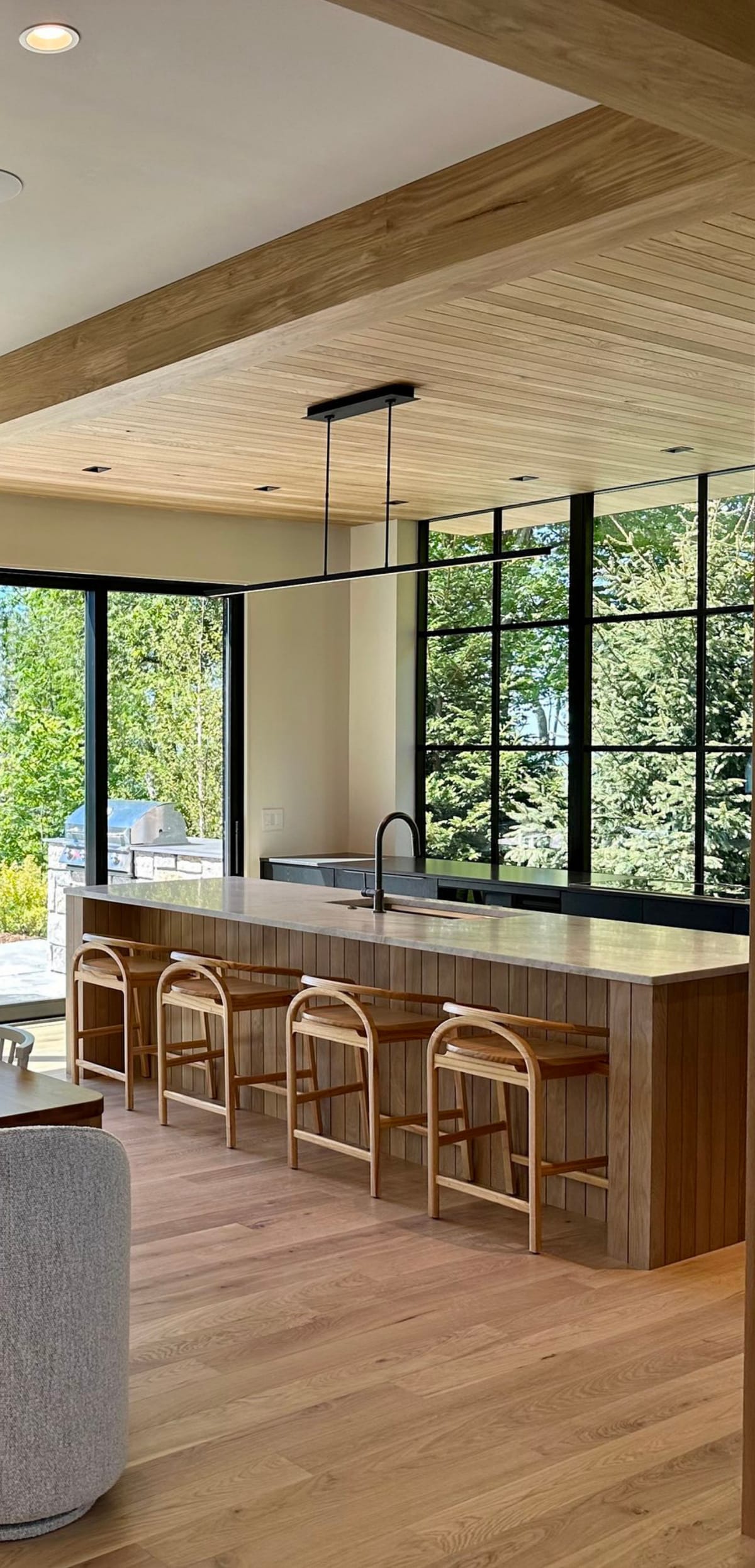 Kitchen island with wood stools and black windows