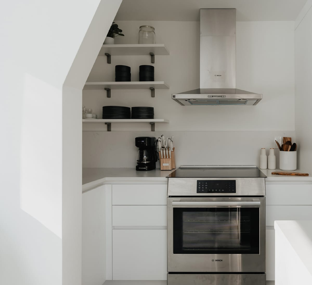 Range and open shelves under a sloped ceiling