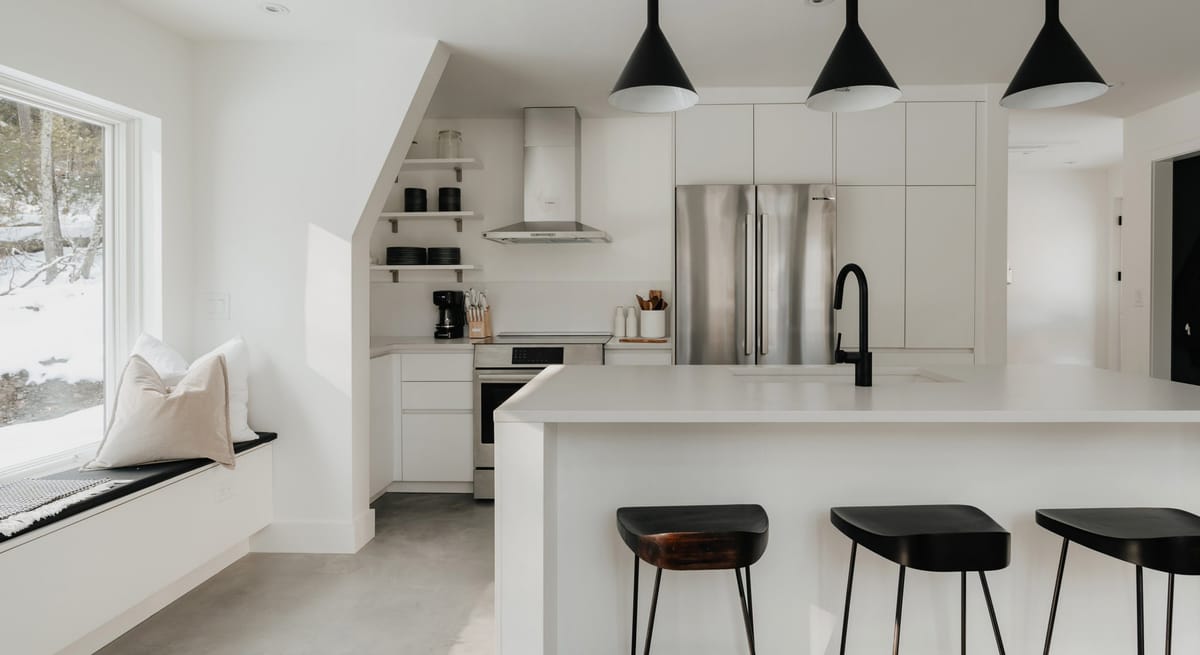 Kitchen with black stools and a window seat